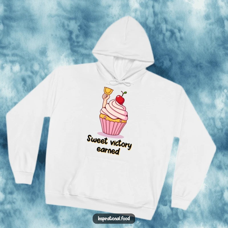 Smiling cupcake victoriously holding a cherry on a soft, cozy hoodie. Sweet comfort.